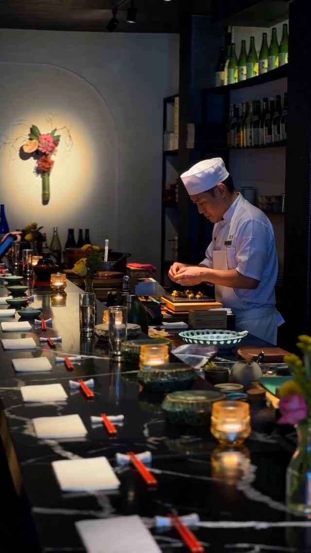 Chef preparing an omakase course at Zama’s intimate, candlelit sushi counter