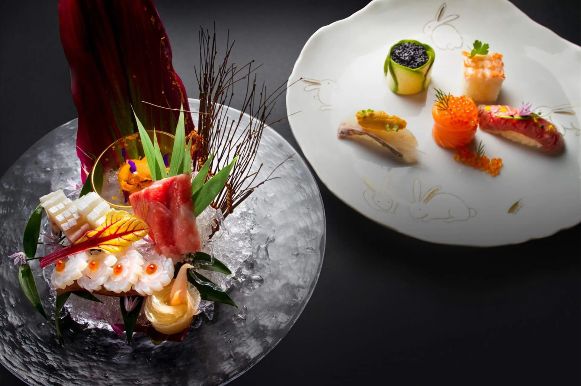 Elegant sashimi and sushi with artistic plating on dark dishware.